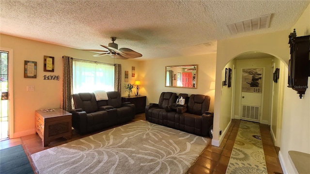 tiled living room featuring ceiling fan and a textured ceiling