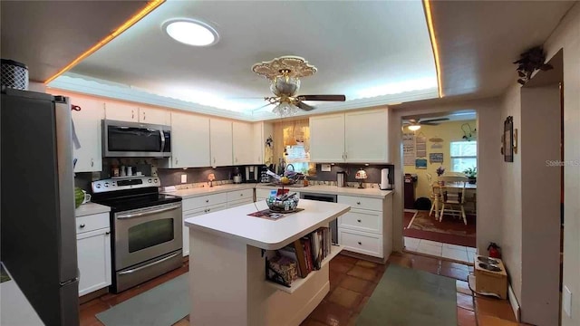 kitchen featuring a center island, appliances with stainless steel finishes, white cabinets, and ceiling fan