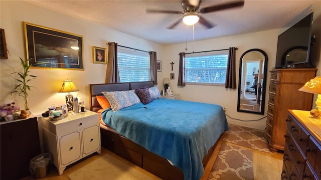 bedroom with light hardwood / wood-style floors and ceiling fan