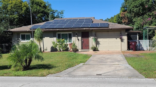 ranch-style home featuring a front yard, solar panels, and a garage