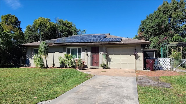 ranch-style home with a front yard, a garage, and solar panels