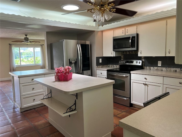 112 10th St, Saint Cloud, FL 34769 - kitchen with stainless steel appliances, ceiling fan, a kitchen island, light countertops, and dark tile patterned flooring