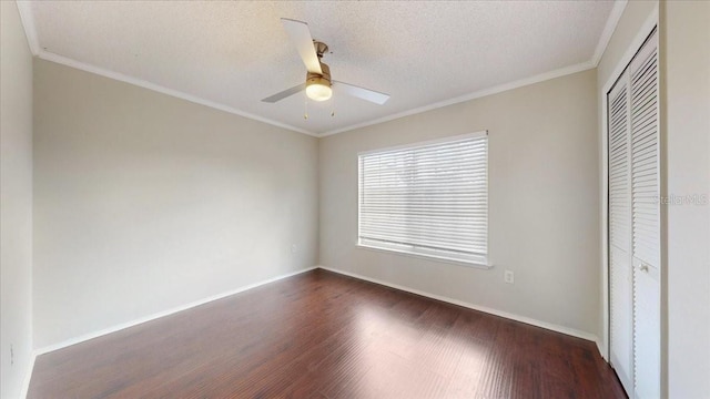 unfurnished bedroom featuring ceiling fan, dark wood-type flooring, crown molding, a textured ceiling, and a closet