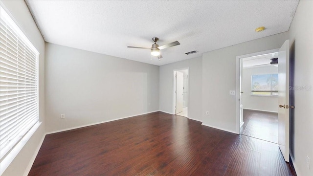 spare room featuring ceiling fan, dark hardwood / wood-style flooring, and a textured ceiling