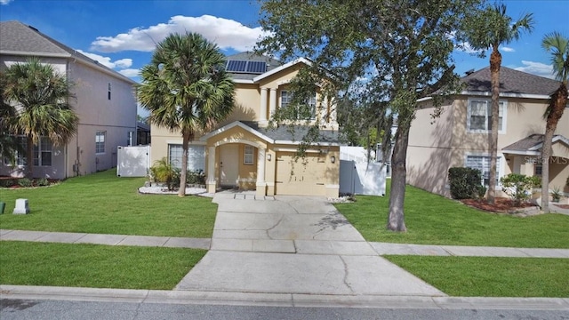 view of front of property featuring solar panels, a front yard, and a garage