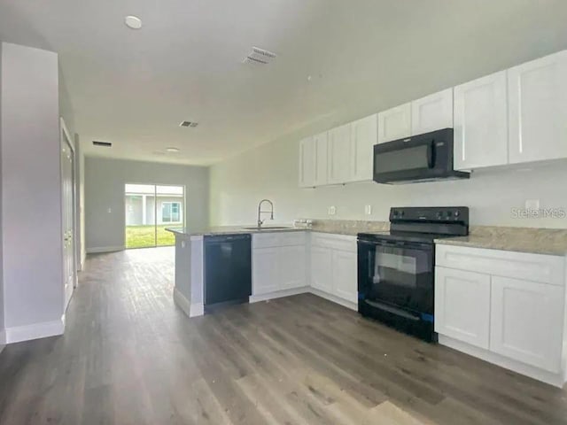 kitchen with black appliances, white cabinets, kitchen peninsula, and dark wood-type flooring