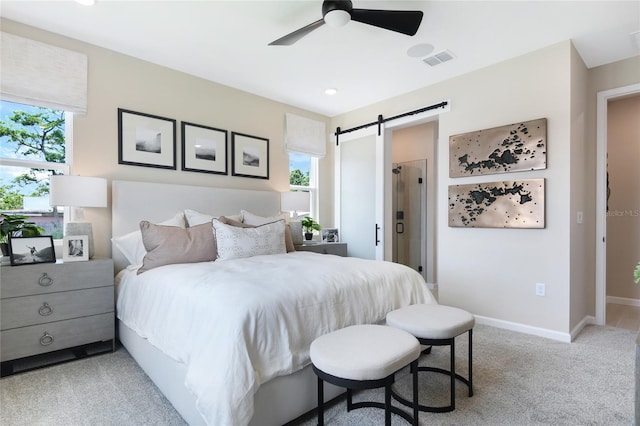 bedroom featuring light carpet, a barn door, and ceiling fan