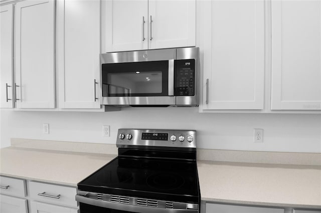 kitchen with light countertops, appliances with stainless steel finishes, and white cabinets