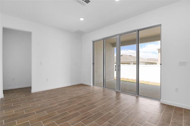 empty room with wood tiled floor, baseboards, recessed lighting, and visible vents
