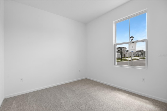 empty room featuring baseboards and carpet floors