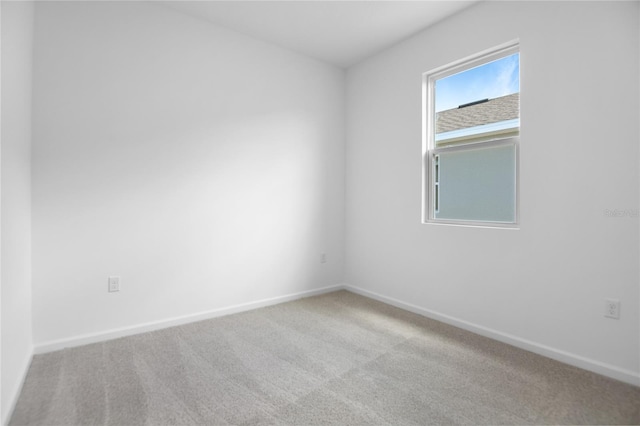 carpeted empty room featuring baseboards