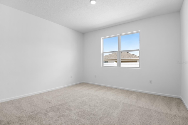 unfurnished room featuring baseboards and light colored carpet