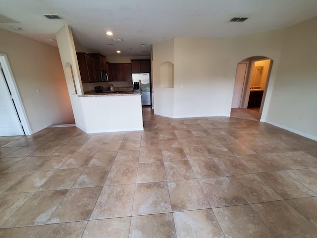 kitchen featuring stainless steel fridge with ice dispenser and dark brown cabinets