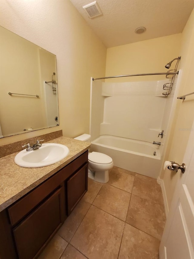 full bathroom featuring tile patterned floors, toilet, shower / tub combination, vanity, and a textured ceiling