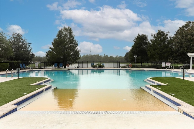 view of swimming pool featuring a yard