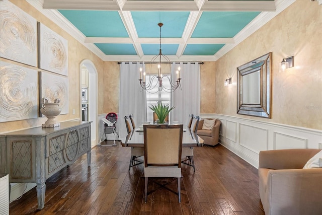 dining space with coffered ceiling, beamed ceiling, dark wood-type flooring, crown molding, and a chandelier