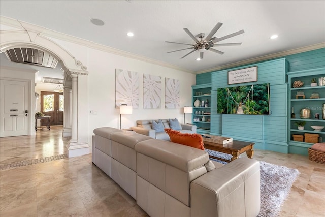 living room featuring ornamental molding, built in shelves, ornate columns, and ceiling fan