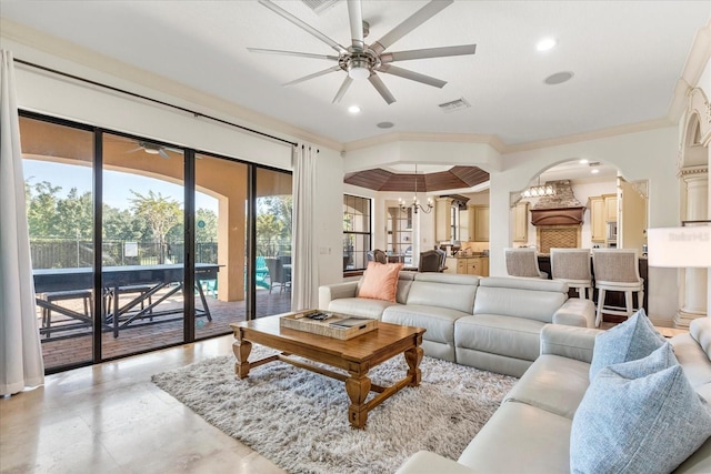 living room featuring crown molding and ceiling fan with notable chandelier