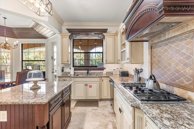 kitchen featuring appliances with stainless steel finishes, cream cabinets, and decorative light fixtures