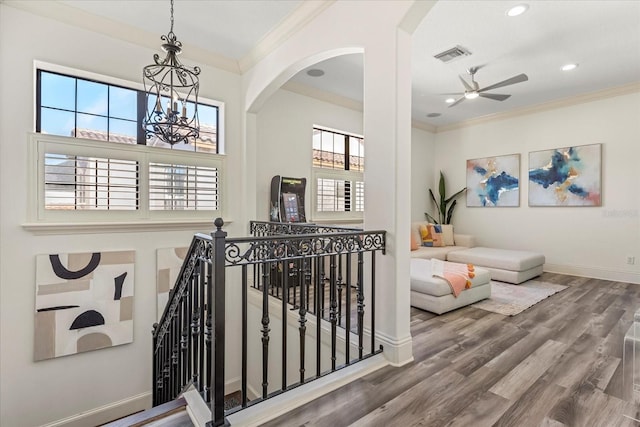 corridor with crown molding, wood-type flooring, and plenty of natural light