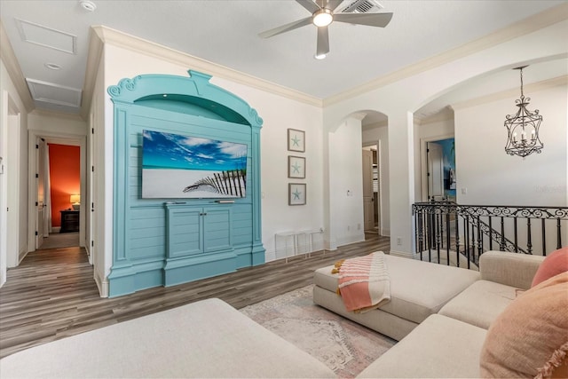 living room with ornamental molding, hardwood / wood-style flooring, and ceiling fan with notable chandelier