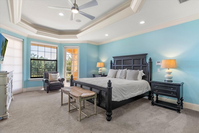 carpeted bedroom with ornamental molding, a tray ceiling, and ceiling fan