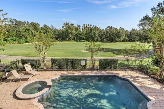 view of pool featuring an in ground hot tub, a patio area, and a lawn