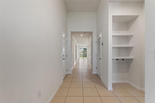 corridor featuring built in features and light tile patterned floors