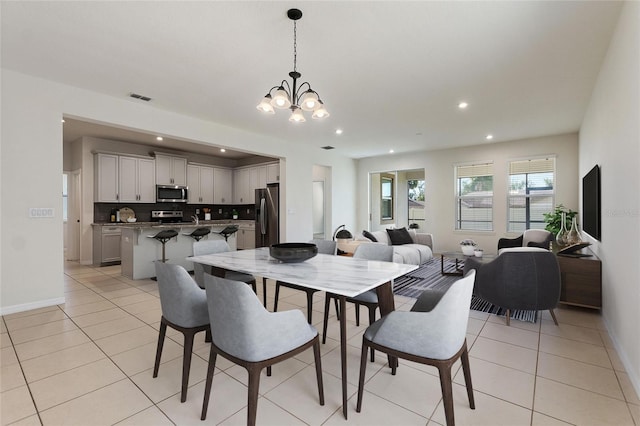 tiled dining room with a notable chandelier