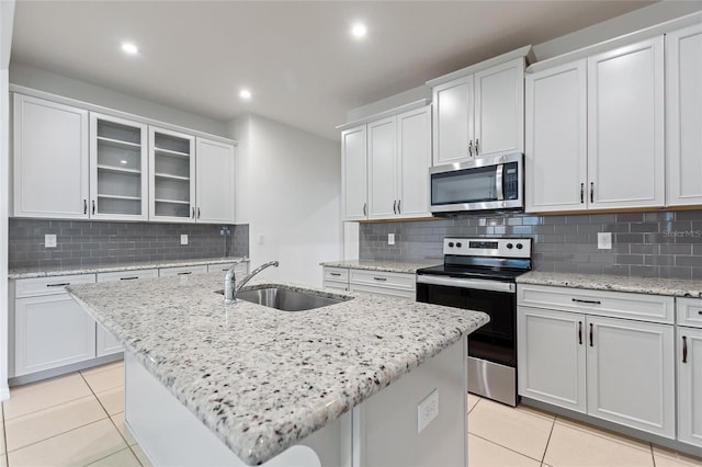 kitchen with stainless steel appliances, sink, a center island with sink, and white cabinets