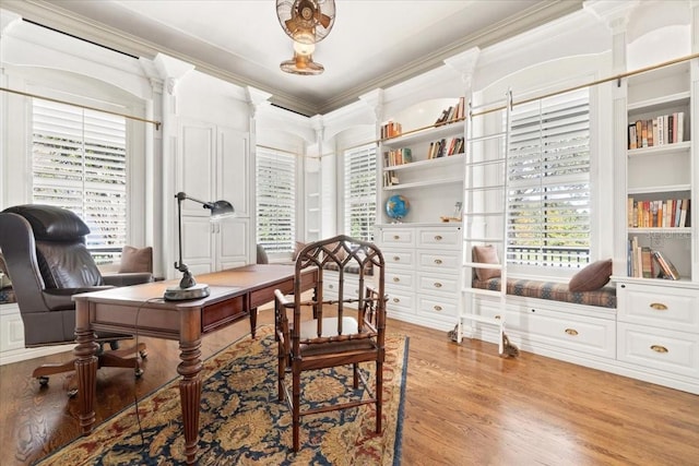 office area with a wealth of natural light, crown molding, and light wood-type flooring