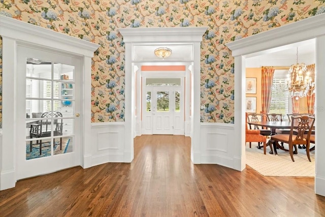 foyer with a wealth of natural light, hardwood / wood-style flooring, and an inviting chandelier