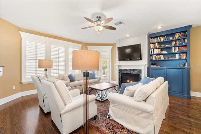 living room featuring ceiling fan, dark hardwood / wood-style flooring, and a fireplace