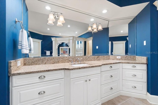 kitchen featuring white cabinets, light tile patterned floors, light stone countertops, ornamental molding, and sink