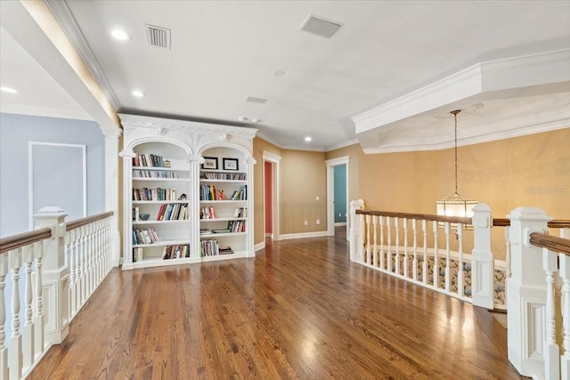 interior space with dark wood-type flooring, ornamental molding, and an inviting chandelier