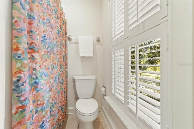 bathroom with toilet, tile patterned flooring, and a shower with shower curtain