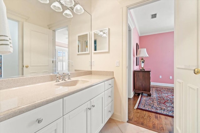 bathroom featuring vanity, crown molding, and hardwood / wood-style floors