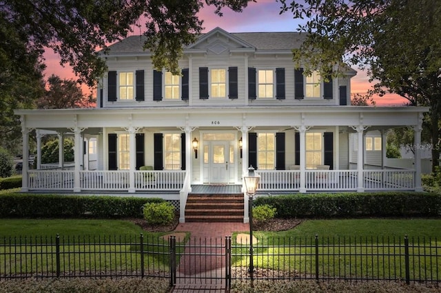 view of front of house featuring covered porch and a lawn