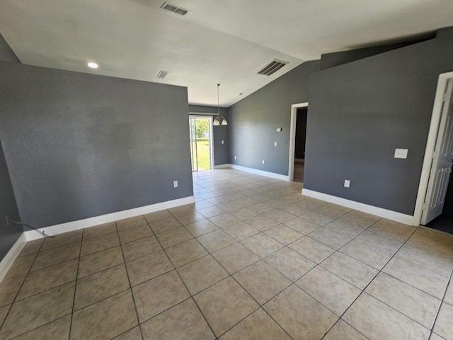 tiled empty room with an inviting chandelier and lofted ceiling