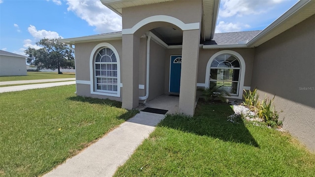 view of exterior entry featuring a yard