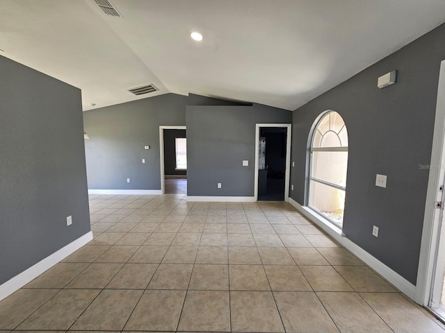 spare room with lofted ceiling and light tile patterned floors