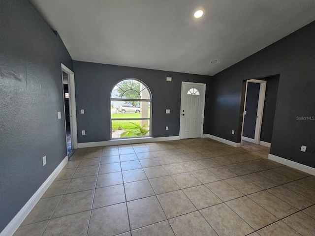 tiled foyer entrance with vaulted ceiling