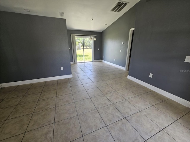 tiled spare room with lofted ceiling and a notable chandelier