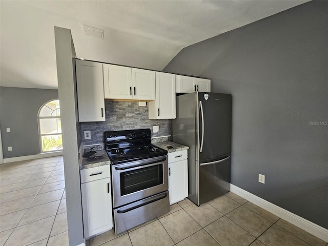 kitchen with white cabinetry, light tile patterned flooring, appliances with stainless steel finishes, and lofted ceiling