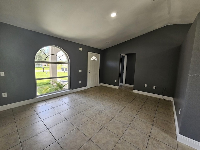 entryway with lofted ceiling and light tile patterned floors