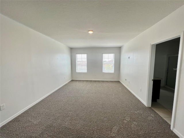 empty room with carpet flooring and a textured ceiling