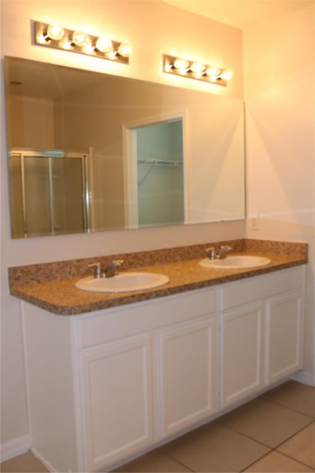 bathroom featuring tile patterned flooring, vanity, and a shower with shower door