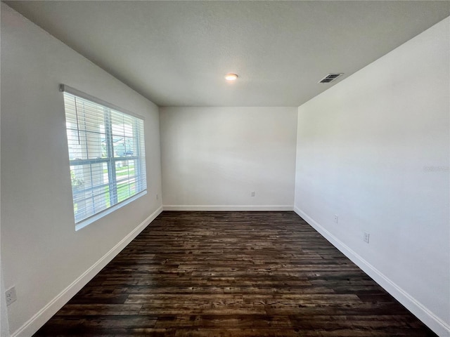 spare room with dark wood-type flooring