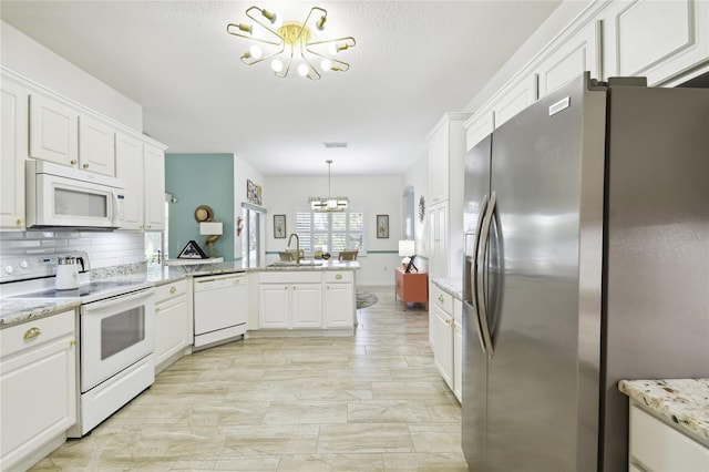 kitchen featuring a notable chandelier, white cabinetry, white appliances, and sink