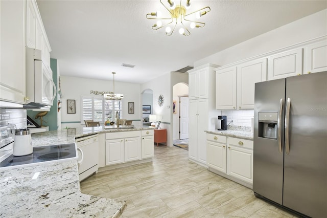 kitchen featuring white appliances, white cabinets, sink, decorative backsplash, and light stone countertops